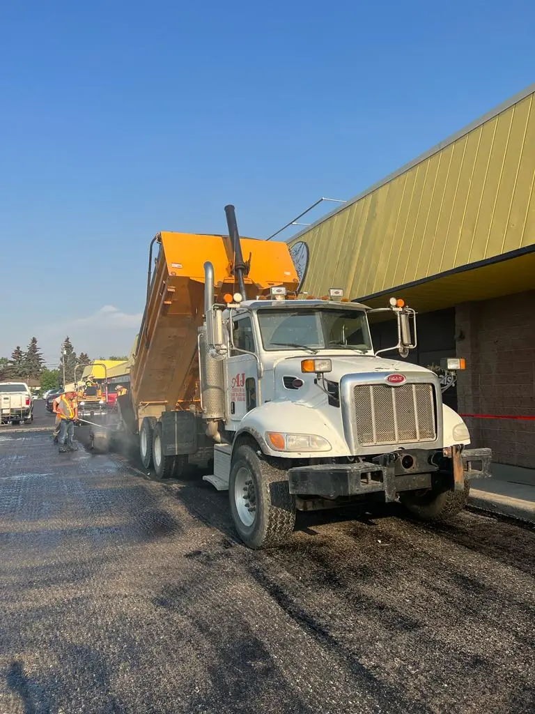 Dump truck with raised bed paving road